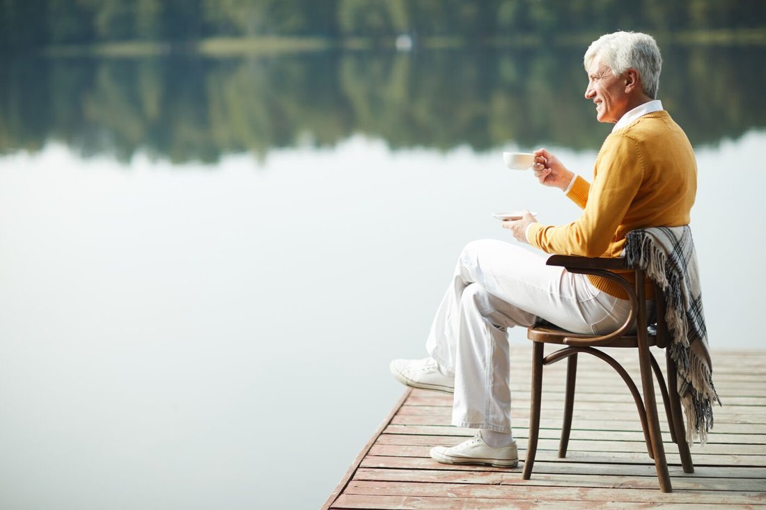 Retired business owner enjoying a quiet morning by the lake